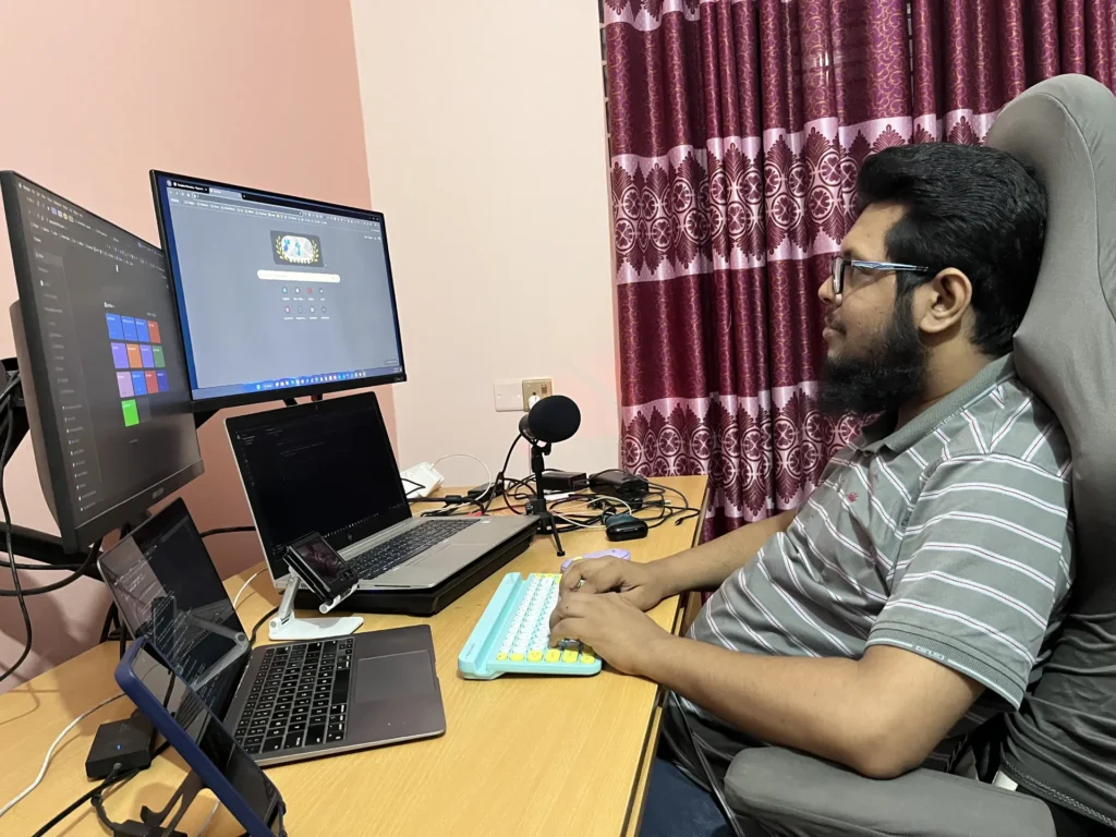 Galib working at a multi-monitor desk setup